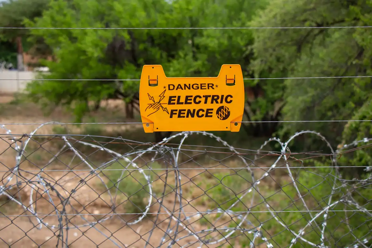 Electric fence warning sign on razor wire