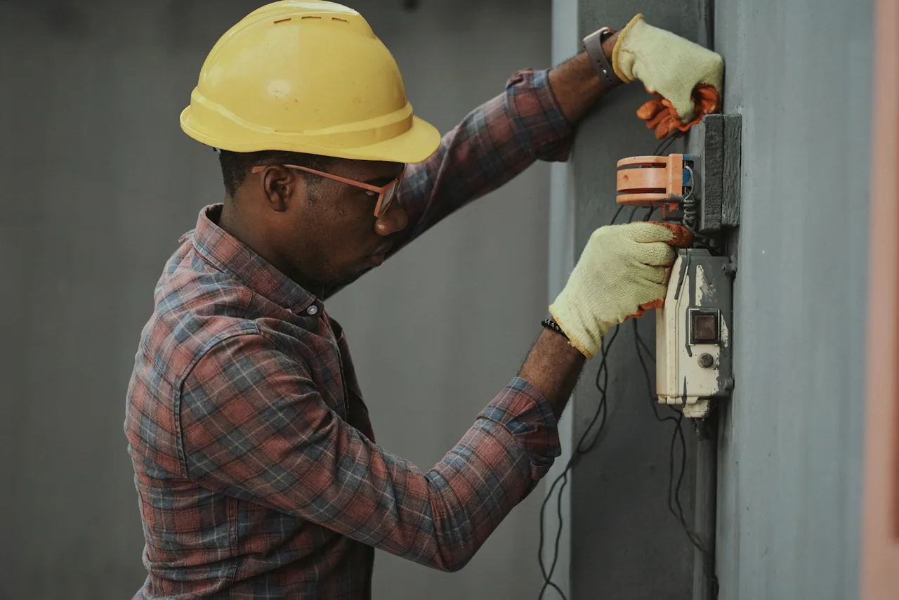 Technician inspecting wall-mounted equipment
