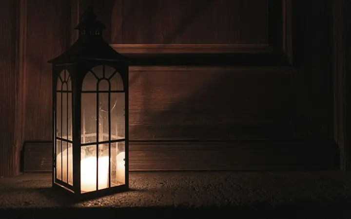 A candle by the door in the dark